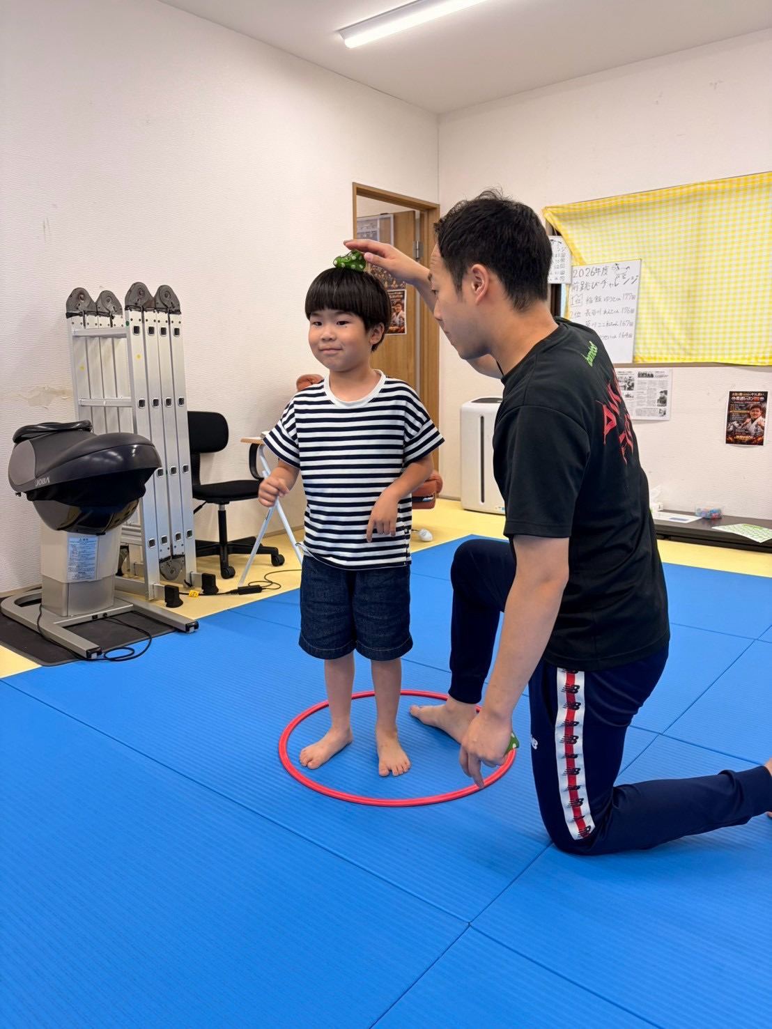 マンツーマンでフープを使った運動指導を受けるお子様