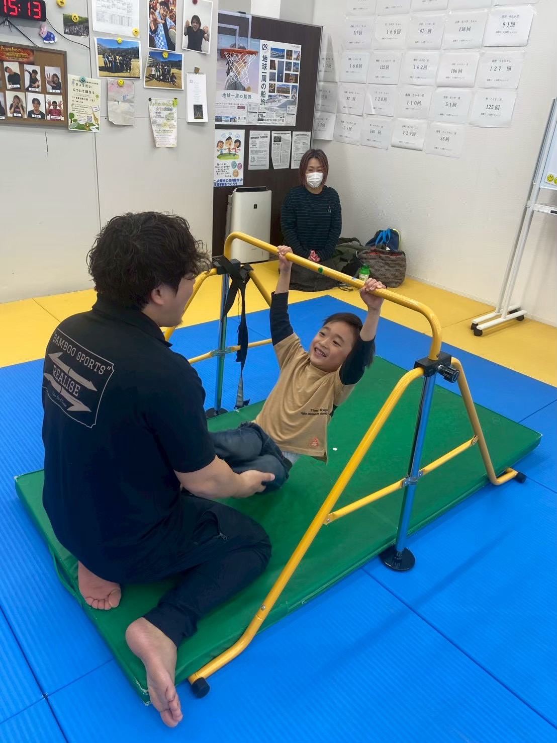 鉄棒に取り組むお子様を保護者が見守る様子