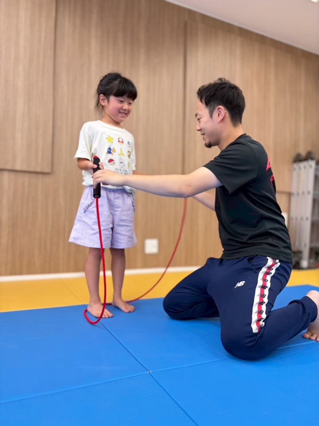 スタッフになわとびを教わるお子さま