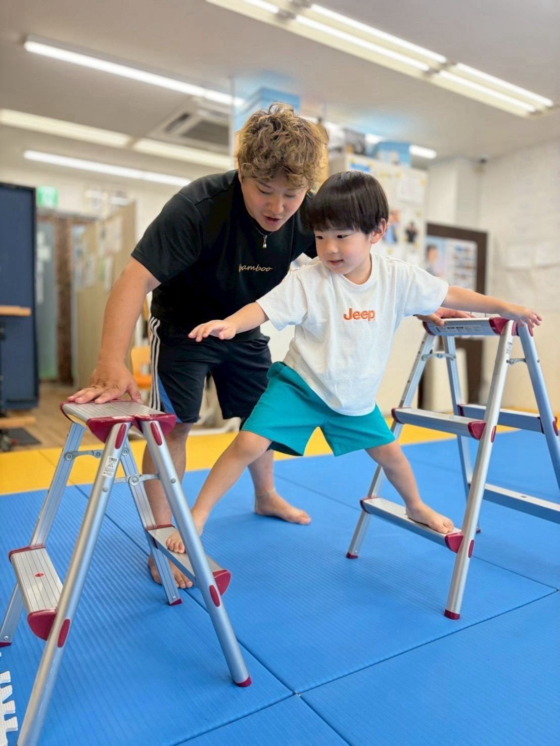 平均台を使った運動療育に取り組むお子さまとスタッフ